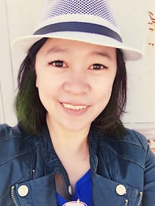 CenYing教學總監Celine Chou身穿白帽與藍色外套,面帶親切微笑。
